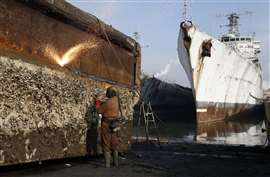 A worker dismantling a vessel with a specialist blow torch