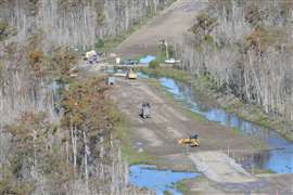 Construction machinery works on storm and hurricane risk reduction infrastructure