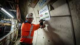 A Strabag UK worker installs a plaque marking the 25.8km distance the tunnelling team has achieved so far 