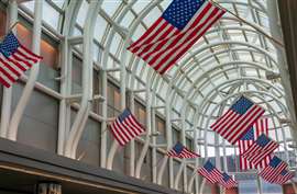American flags line a walkway in Chicago O'Hare's International Airport. (Image: Adobe Stock)