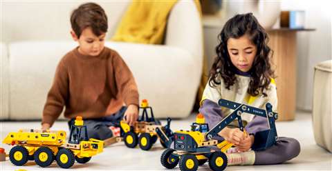 A little boy and girl playing with the Volvo Brio toys in their living room