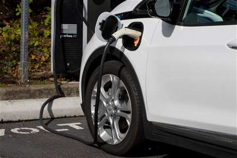 A Chevy Bolt EV electric car is seen charging at a Volta Charging Station in a parking lot in Tigard, Oregon.